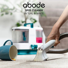 Abode spot cleaner being used on a mug with a cleaning machine in the background.